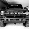 Black & white photo of white vinyl on front window of Ford Bronco