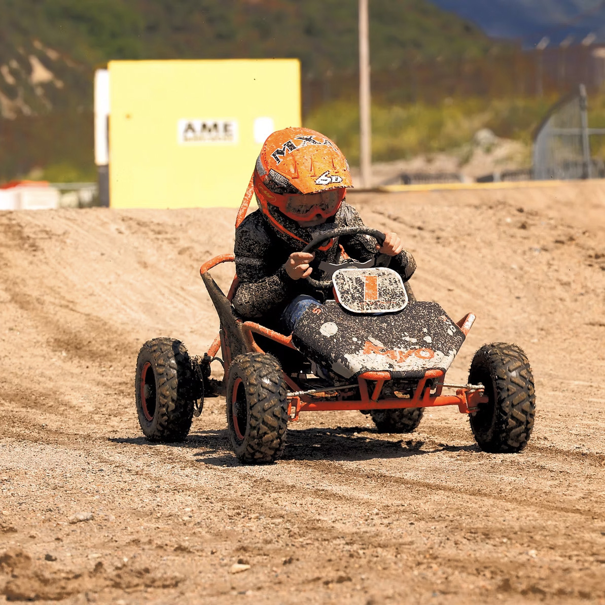 Youth driving Kayo S70 Go-Kart on muddy track
