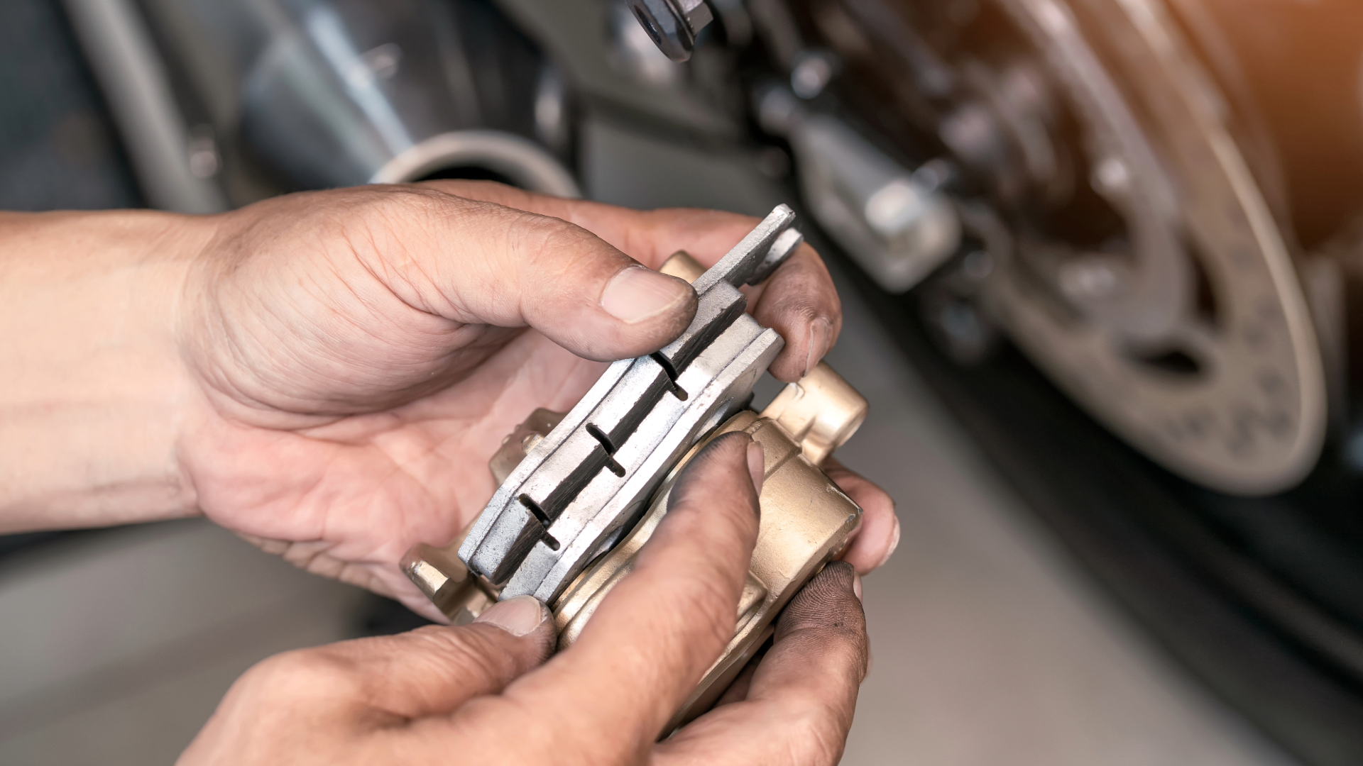 motorcycle rider checking the wear level on brake pads before spring riding