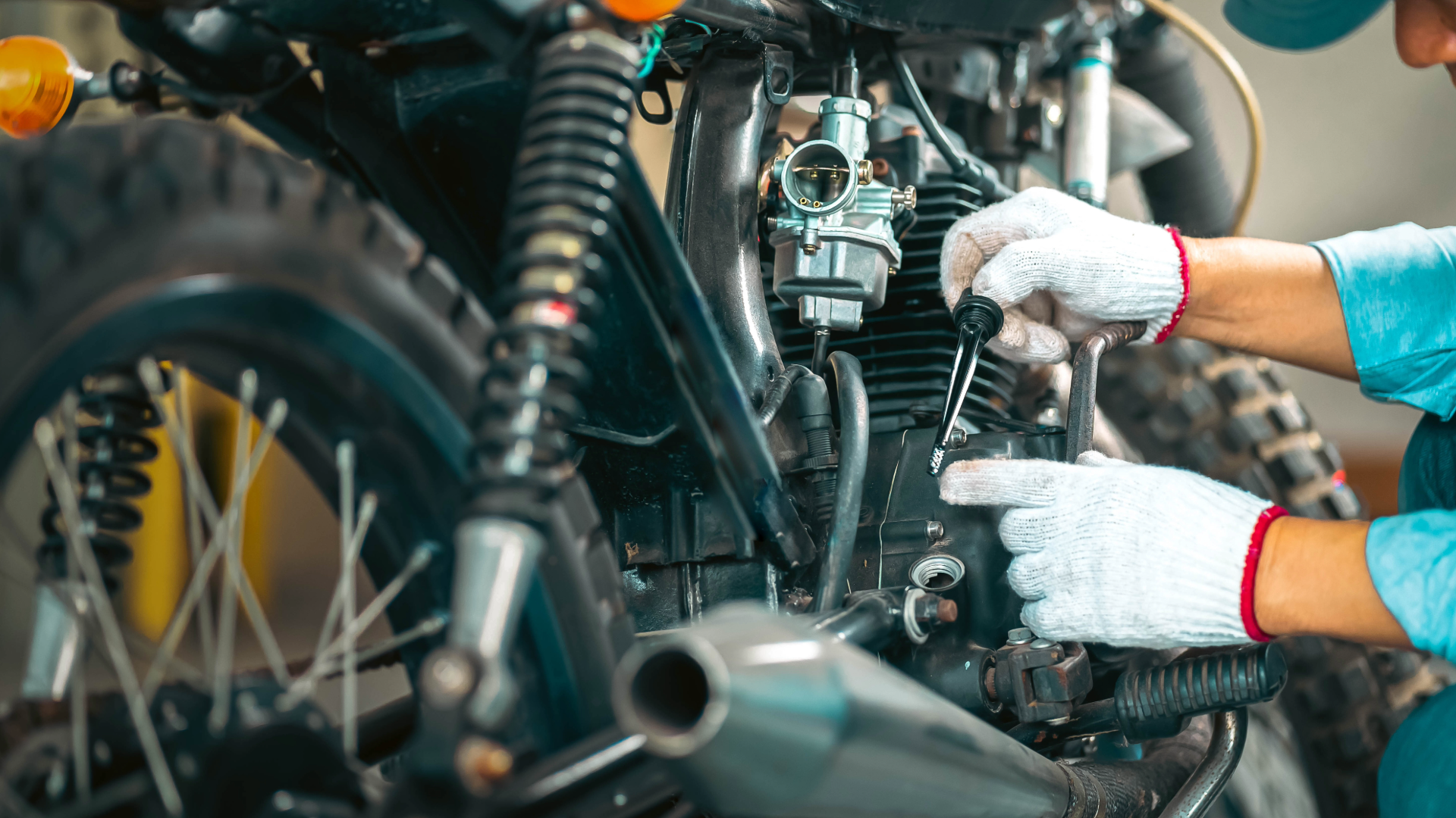 Mechanic checking motorcycle engine oil and brake fluid levels during spring service inspection