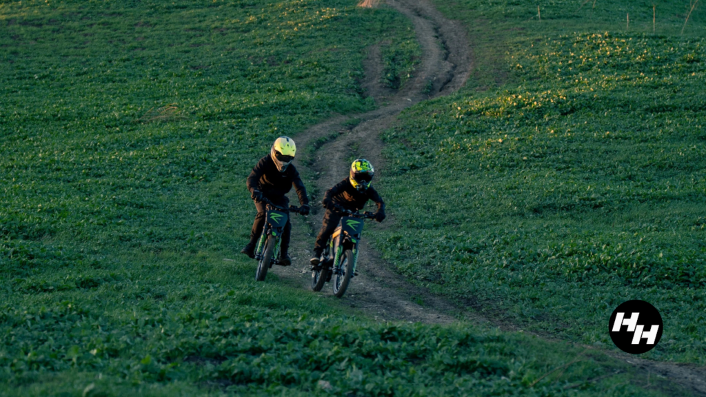 Two riders going down a grassy hill on a Mantis R17 and a Mantis R.