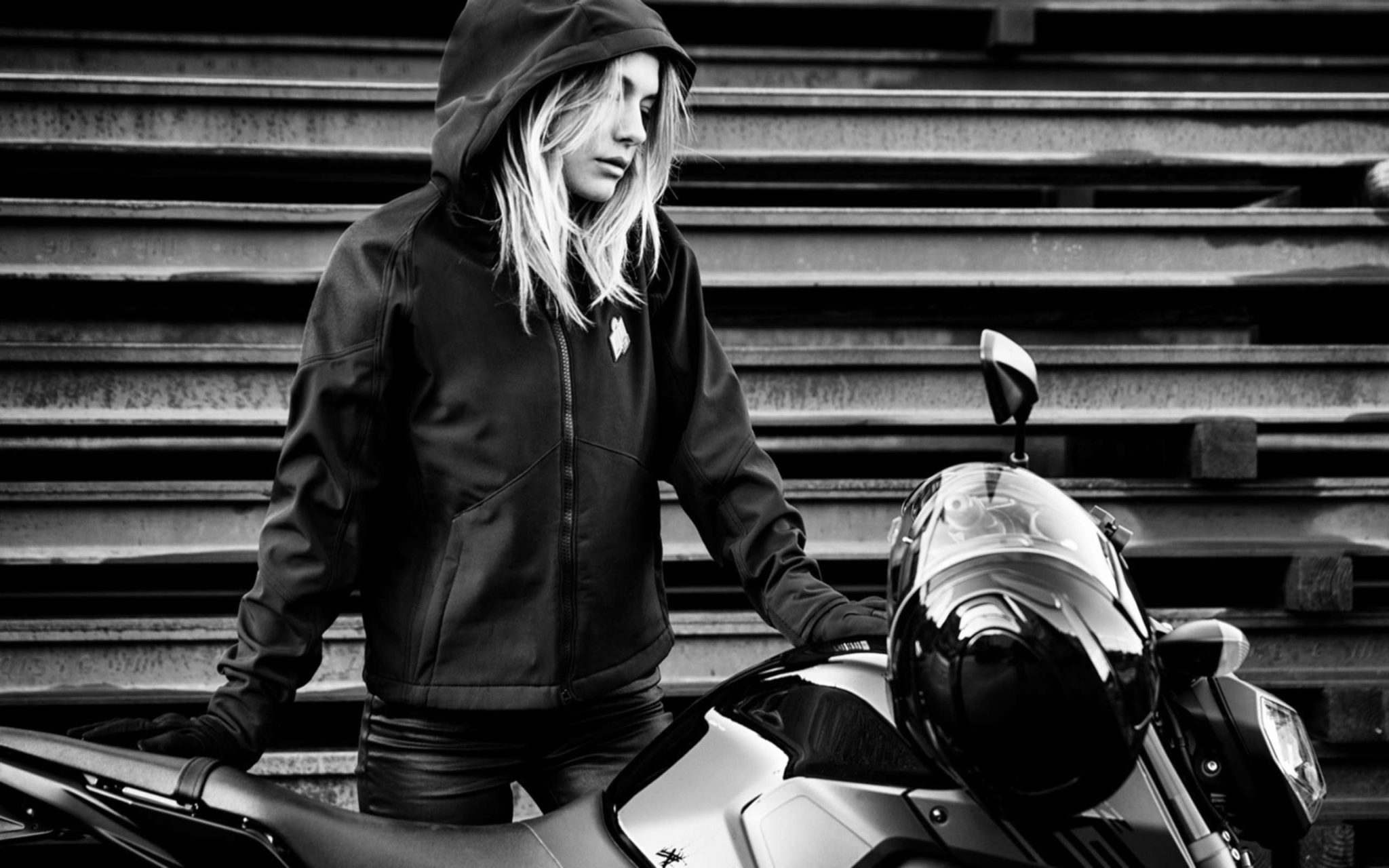 Black and white photo of rider in hooded jacket getting ready to ride
