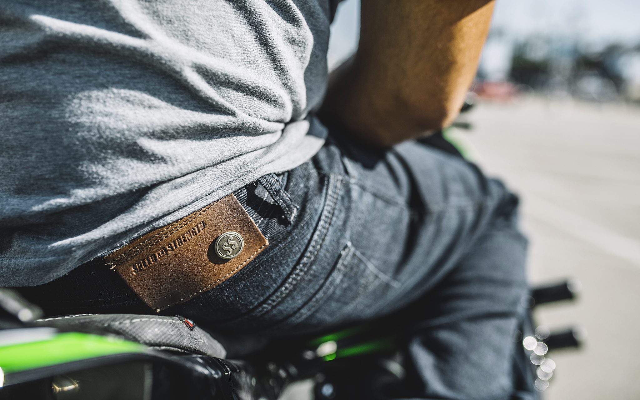 Close up shot of rider wearing motorcycle jeans while sitting on bike