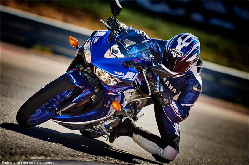 Racer in full blue gear leaning through corner on R3
