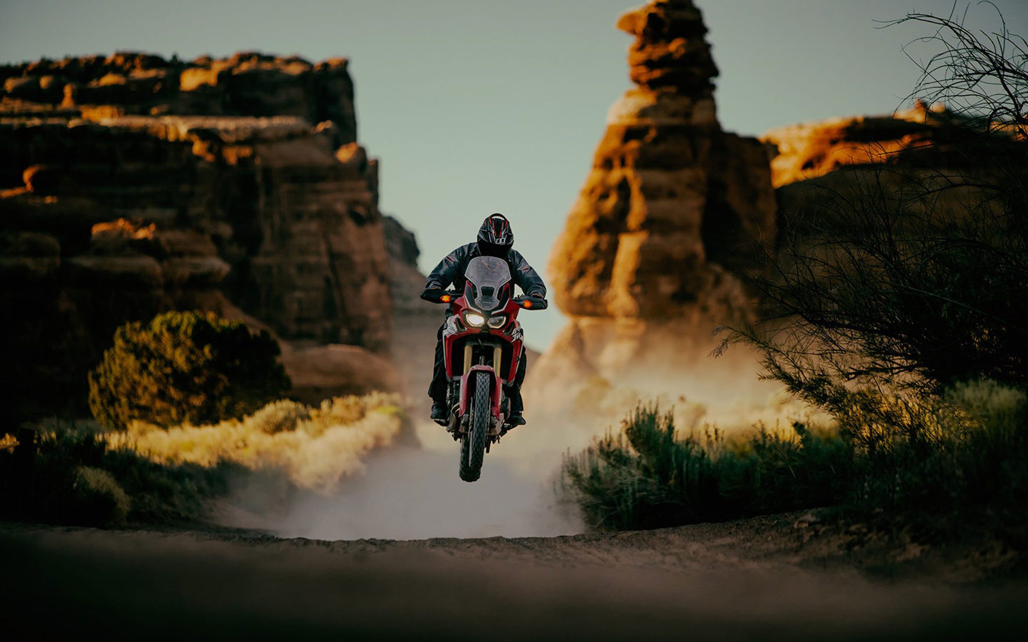 Dual sport rider in the desert catching air