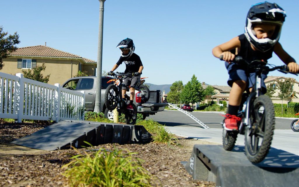 Kids racing over ramps on Stacyc electric bicycles