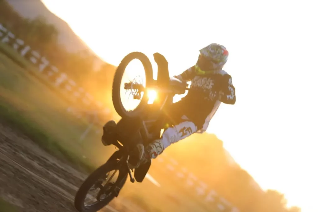 Rider doing wheelie on Rawrr Mantis E-Moto against sunset