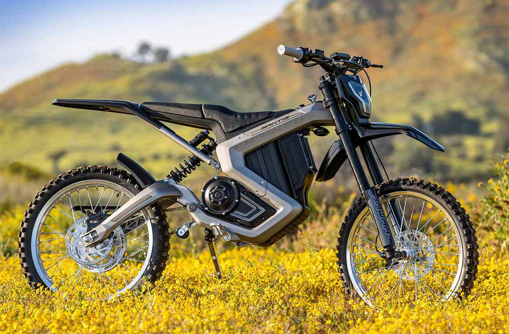 Silver Rawrr Mantis E-Moto parked in field beneath hill
